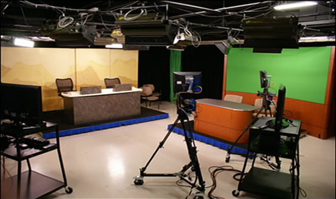 Photo of the studio with green screen, stage, and cameras.